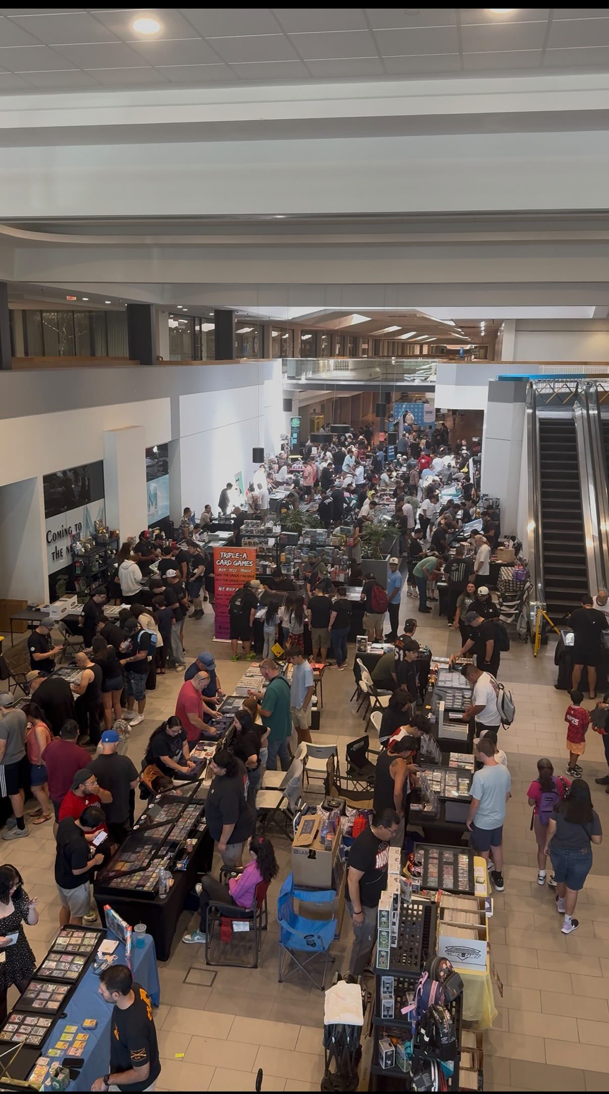 Wide view of packed indoor collector show with long vendor aisles